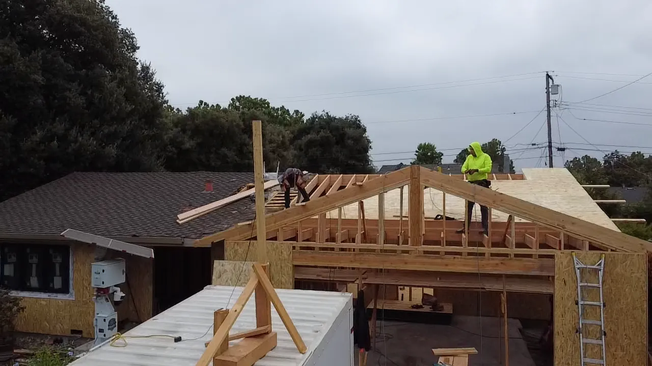 Construction crew framing a roof addition on-site