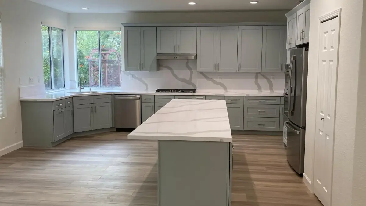 Remodeled kitchen with sage cabinets, counters and an island